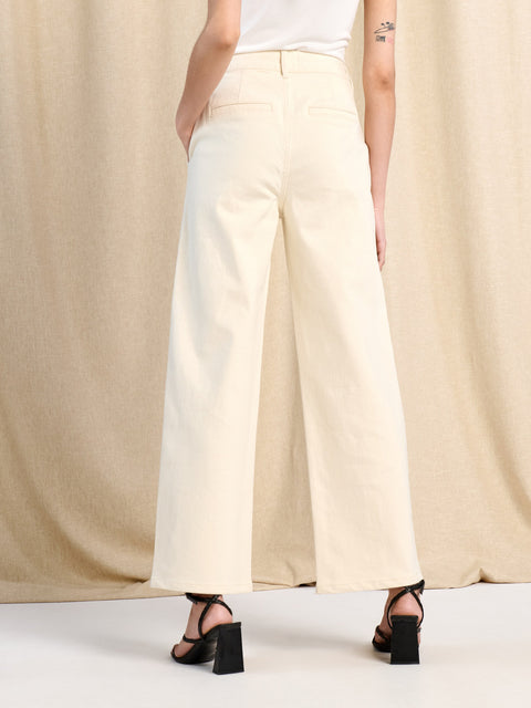 Person wearing beige wide-leg pants against a neutral background