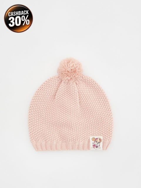 Pink knit beanie with a pom-pom on a light gray background