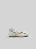 White flat shoe with a bow on a light gray background