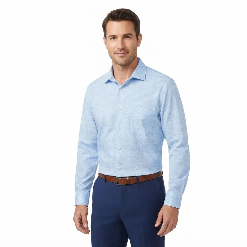A man wearing a light blue long-sleeve button-down dress shirt with navy blue trousers and a brown belt, standing against a plain white background.