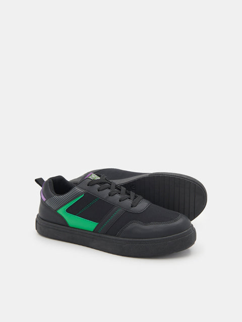 Black sneakers with green accents on a white background