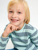 Child wearing a light blue and navy striped shirt against a white background