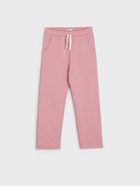 Pink sweatpants with a drawstring on a light gray background