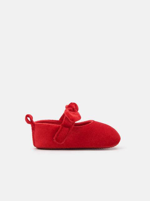 Red baby shoe with a bow on a white background