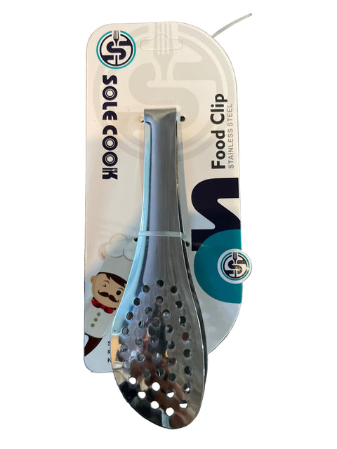 Metallic spatula on a 'Sole Cook' branded card against a wooden background