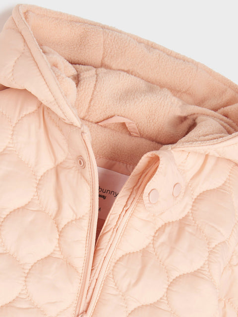 Close-up of a pink quilted jacket with a brand label on a light gray background