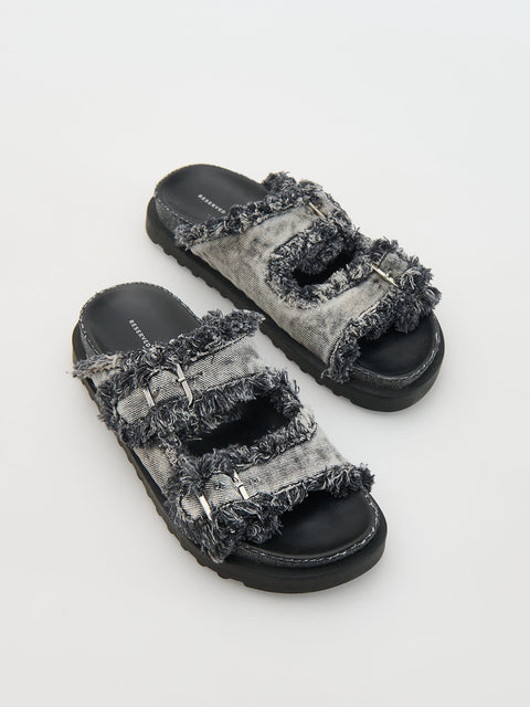 Pair of gray sandals with frayed edges on a light gray background