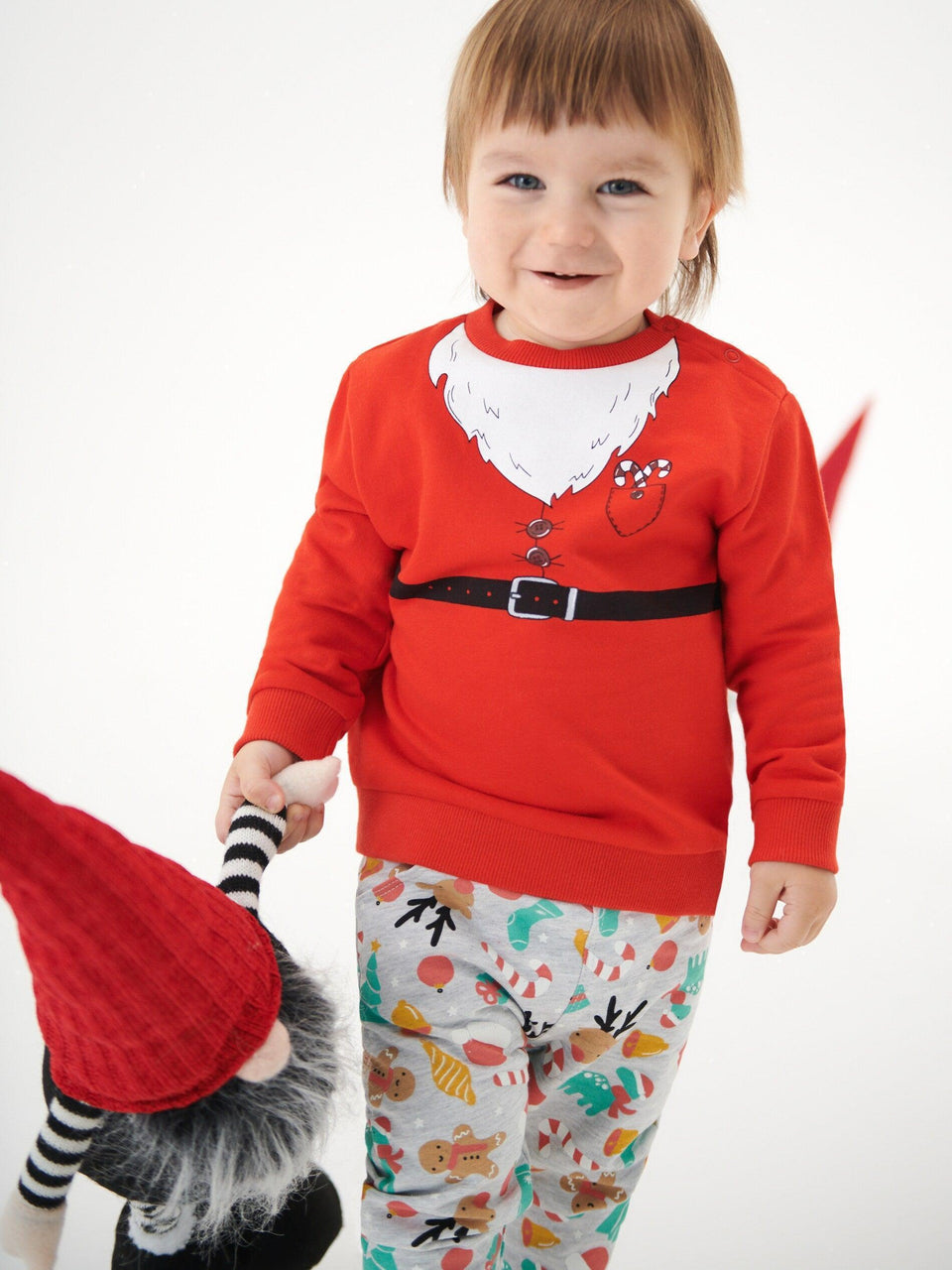 Child wearing a red sweater with a cartoon design on a white background