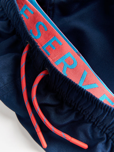 Navy blue shorts with red drawstring and 'RESERVE' text on a white background