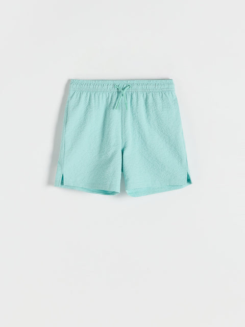 Turquoise shorts on a light gray background