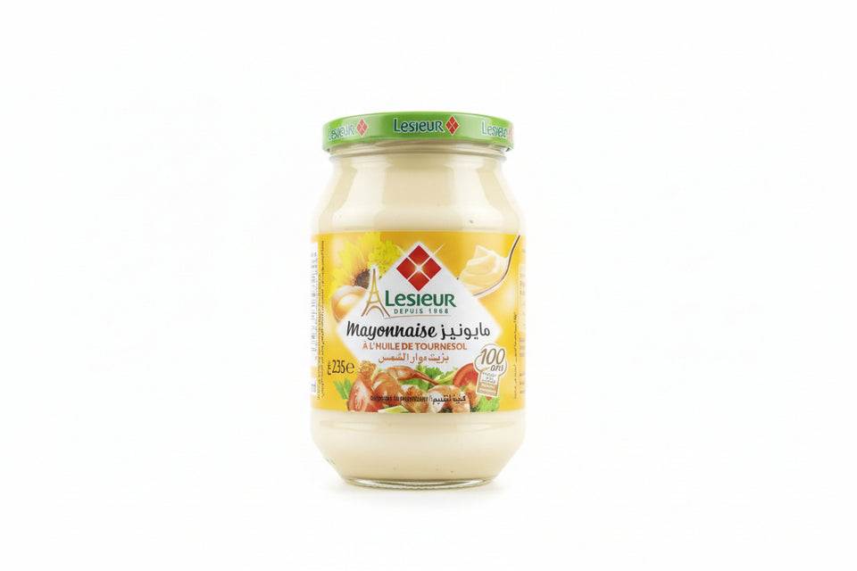 Hand holding a jar of Lesieur mayonnaise on a tiled floor