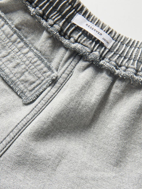 Close-up of a gray denim fabric with a 'RESERVED' label.