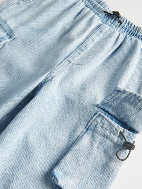 Close-up of light blue denim shorts with a focus on the fabric texture and stitching.