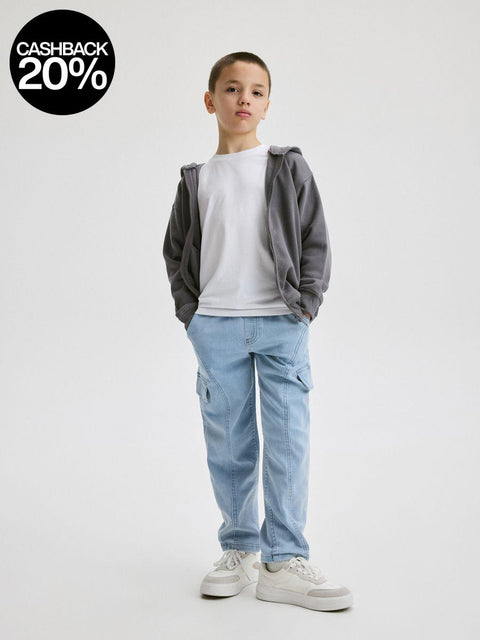 Child wearing a gray hoodie, white t-shirt, blue jeans, and white sneakers on a white background with a cashback 20% badge.