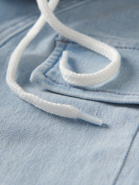 Close-up of white shoelace on a blue denim fabric background