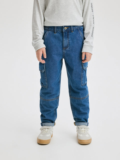 Person wearing blue jeans and a light gray sweatshirt on a white background