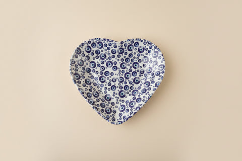 Patterned seat cover on a wooden surface with a black card displaying 'Tucano Milano Italy'.