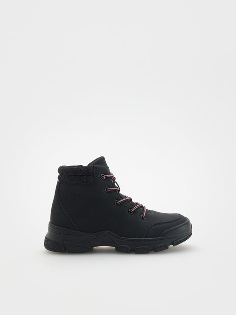 Black winter boot with fur lining on a white background