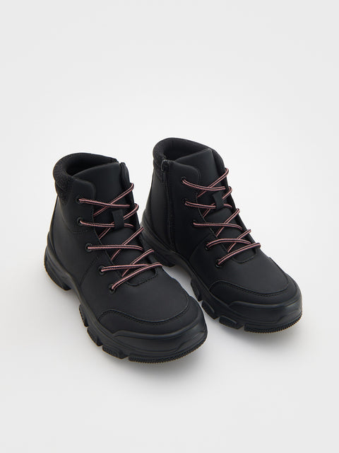 Pair of black high-top boots with brown laces on a white background
