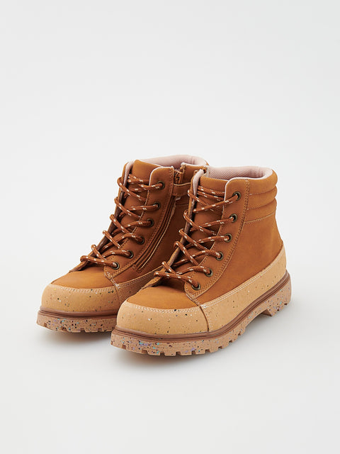 Pair of tan hiking boots with brown laces on a light gray background