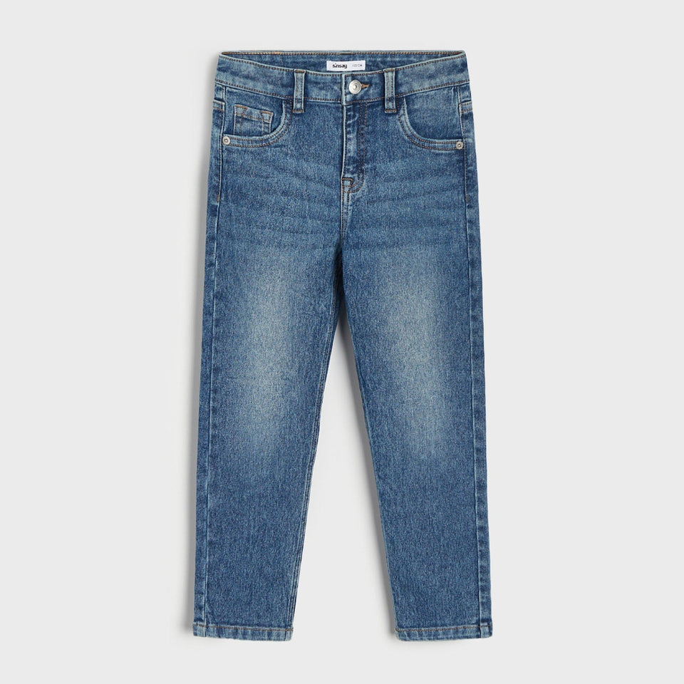 A pair of medium wash blue denim jeans with a slim, tapered leg, shown flat against a light gray background.