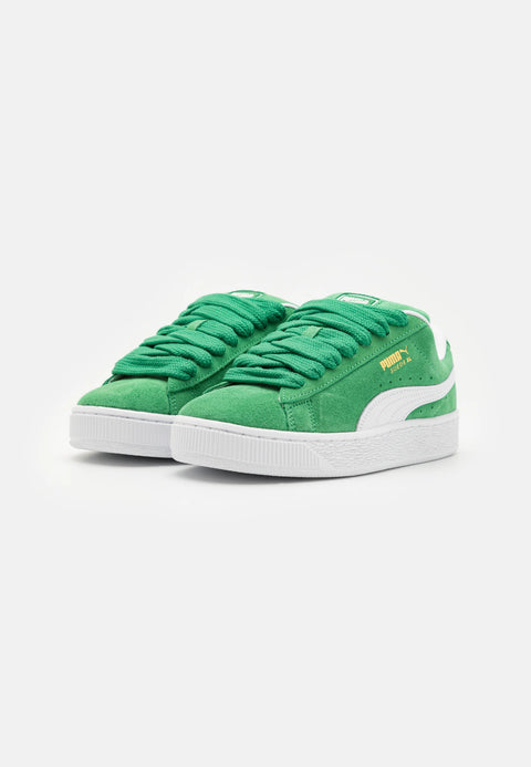 Green sneakers with white soles on a light gray background