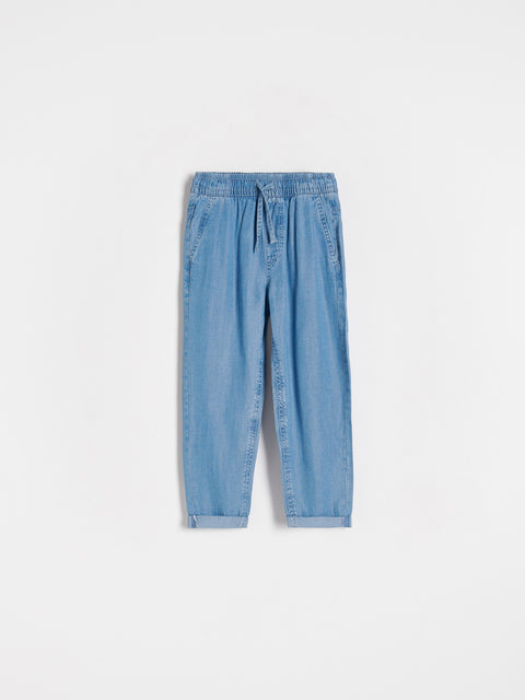 Light blue denim jogger pants on a white background