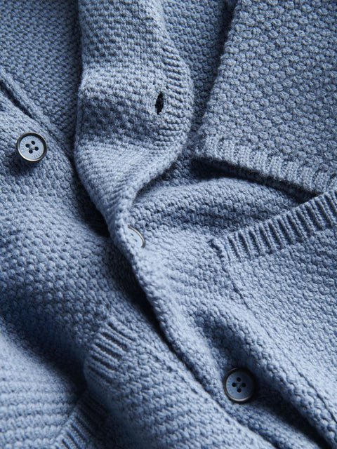 Close-up of a blue knitted cardigan with buttons