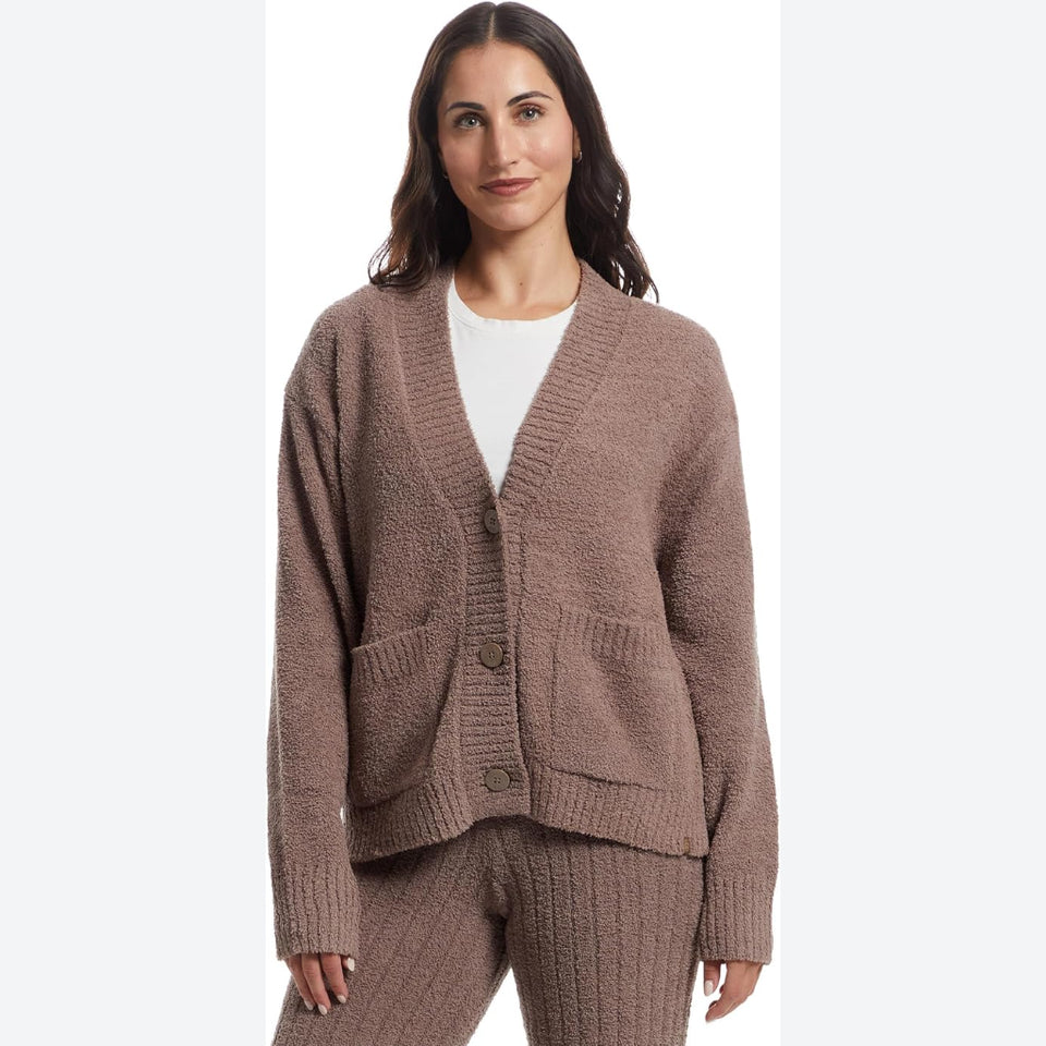 A woman modeling a matching knit cardigan and pants set in a dusty taupe-brown color, styled over a white top against a plain white background.
