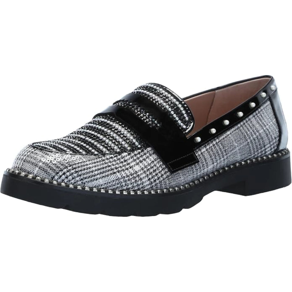 A single women's slip-on loafer with a black and silver houndstooth patterned upper, a wide black strap with silver studs, and a chunky black platform sole.