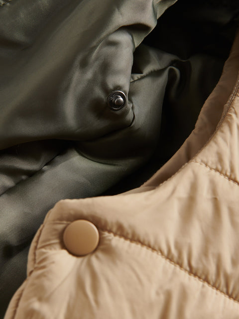 Close-up of a button on a puffer jacket with a blurred background