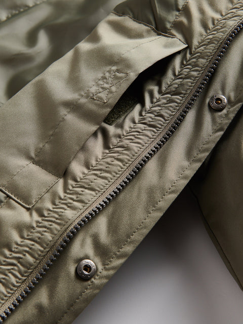Close-up of a green jacket with zipper and button details