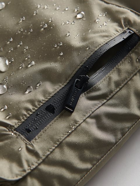 Close-up of a raincoat with water droplets on the fabric and a zipper detail.