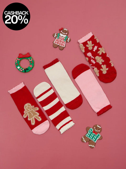 Set of Christmas-themed socks and decorative items on a red background with cashback offer.