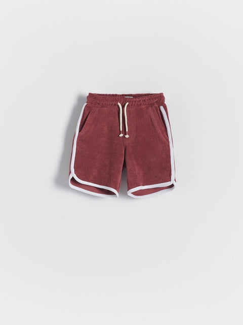 Red shorts with white trim on a light gray background