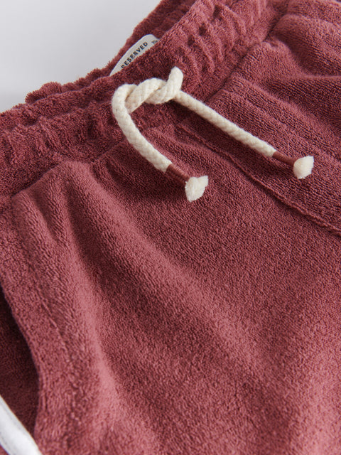 Close-up of maroon shorts with a white drawstring on a white background