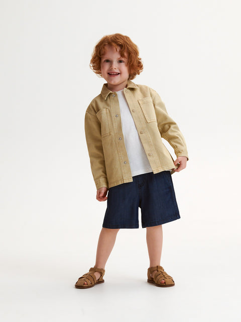 Child wearing a beige jacket, white shirt, navy shorts, and brown sandals on a white background