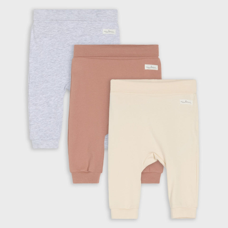 Three pairs of baby jogger pants in light heather gray, dusty rose, and cream, arranged in a stacked layout on a light gray background.
