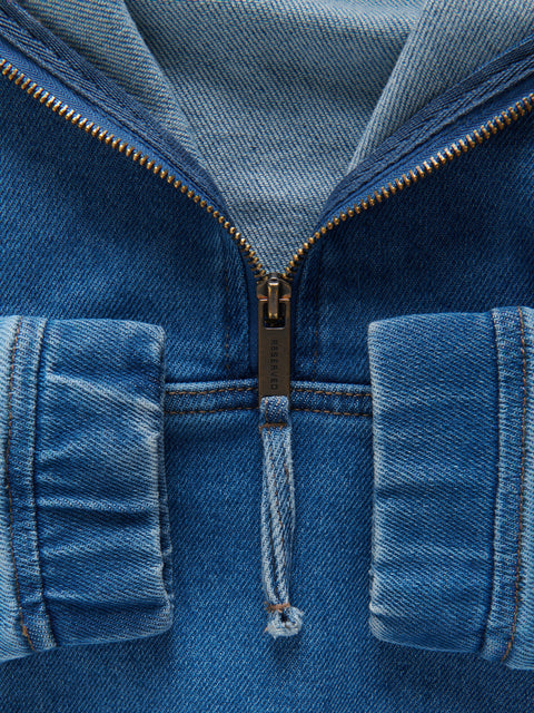 Close-up of a blue denim jacket with a zipper