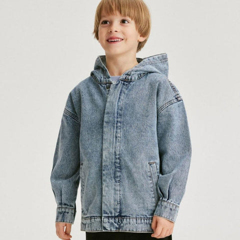 Child wearing a light blue denim jacket on a white background