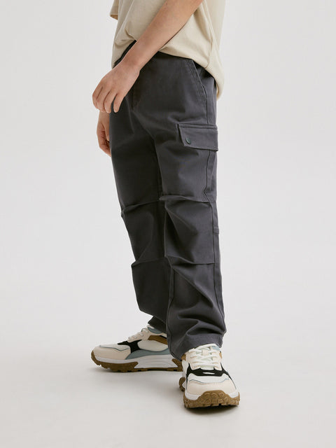 Person wearing dark gray cargo pants on a white background