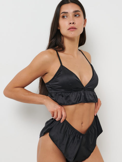 Woman wearing a black bikini against a white background