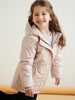 Young girl wearing a light pink jacket with a subtle pattern, standing against a plain background.