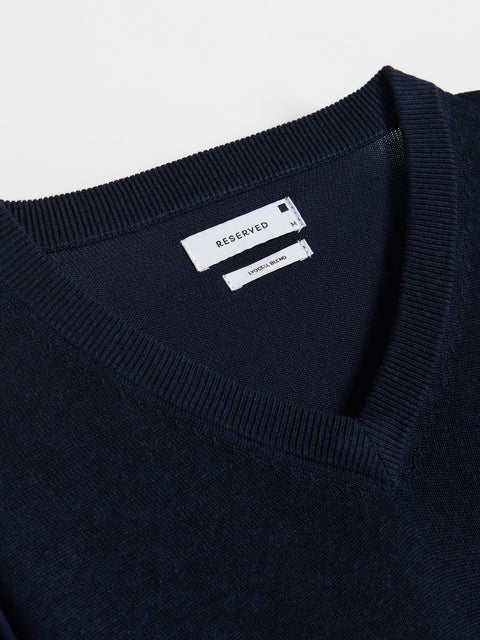 Navy sweater with 'RESERVED' label on a light gray background