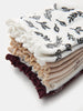 Stack of folded fabric swatches with floral patterns on a white background