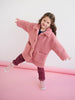 Child wearing a pink coat on a pink background