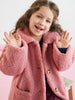Young girl wearing a pink coat with a white background