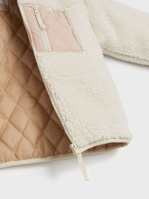 Close-up of a quilted jacket with a zipper on a white background