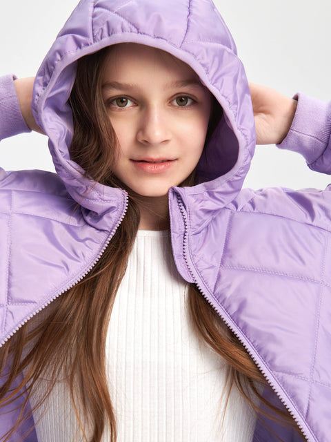Young girl wearing a purple quilted jacket against a light background