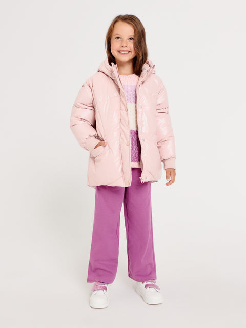 Child wearing a pink puffer jacket and purple pants on a white background